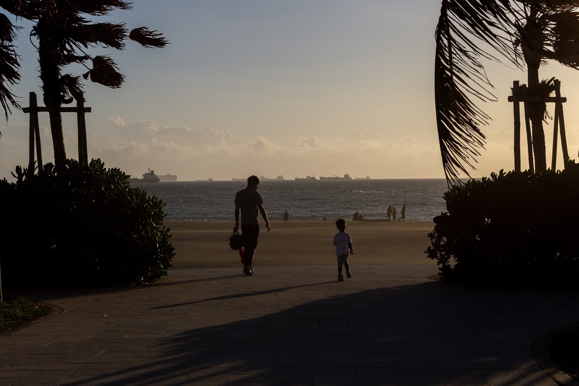 A father and son go for a stroll at sunset